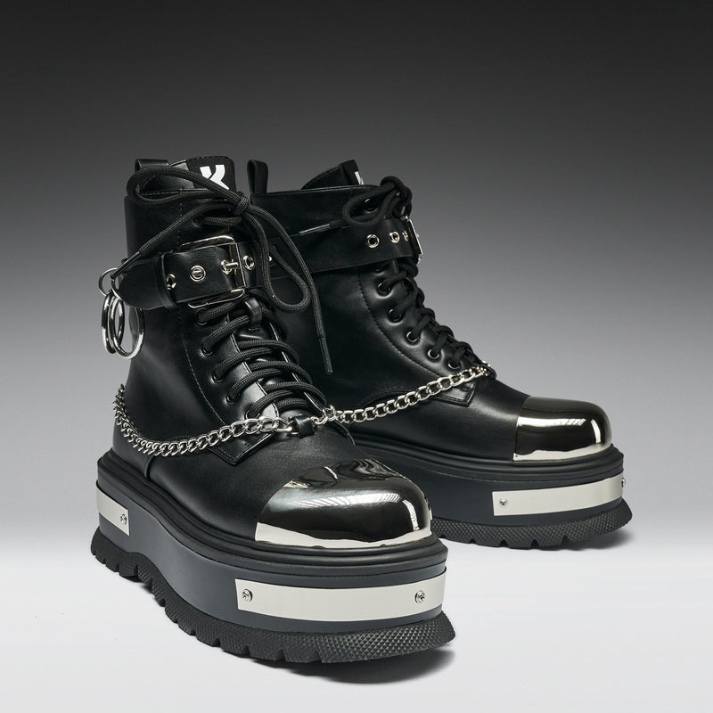 Black high-top boots with chain details on a gradient background