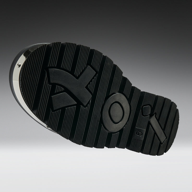 Close-up of a black shoe sole with brand logo on a gradient background