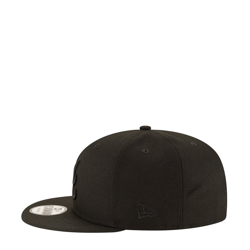 Black baseball cap with small front logo and flat brim, side profile
