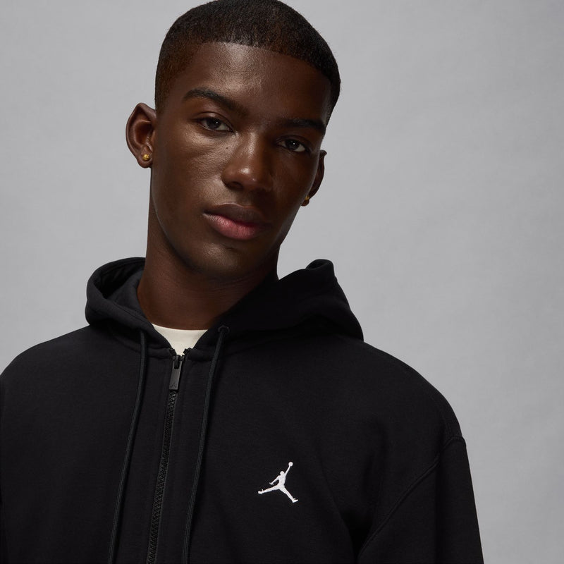 Black hoodie close-up with hood and drawstrings, Jordan logo on chest.
