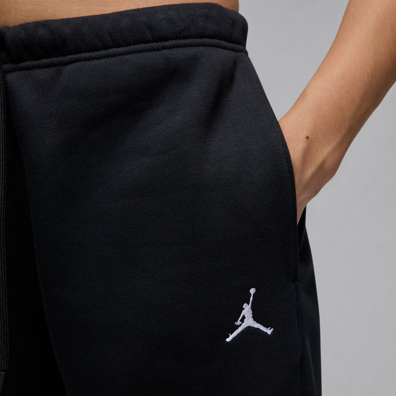 Black fleece sweatpants with embroidered Jumpman-style logo on the thigh