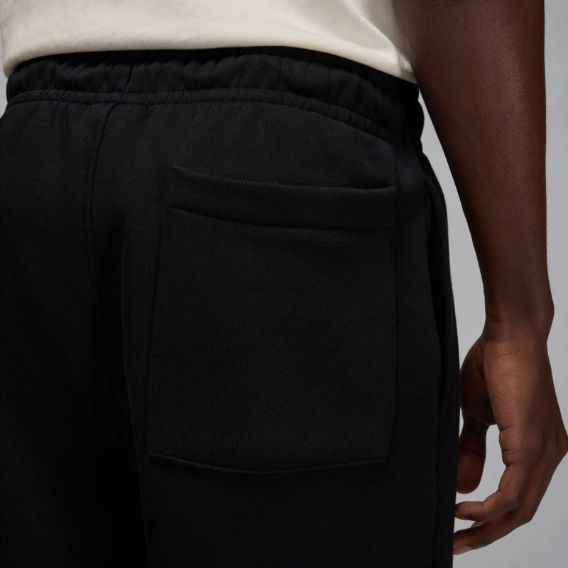 Men's black fleece shorts pocket and drawstring waistband close-up.