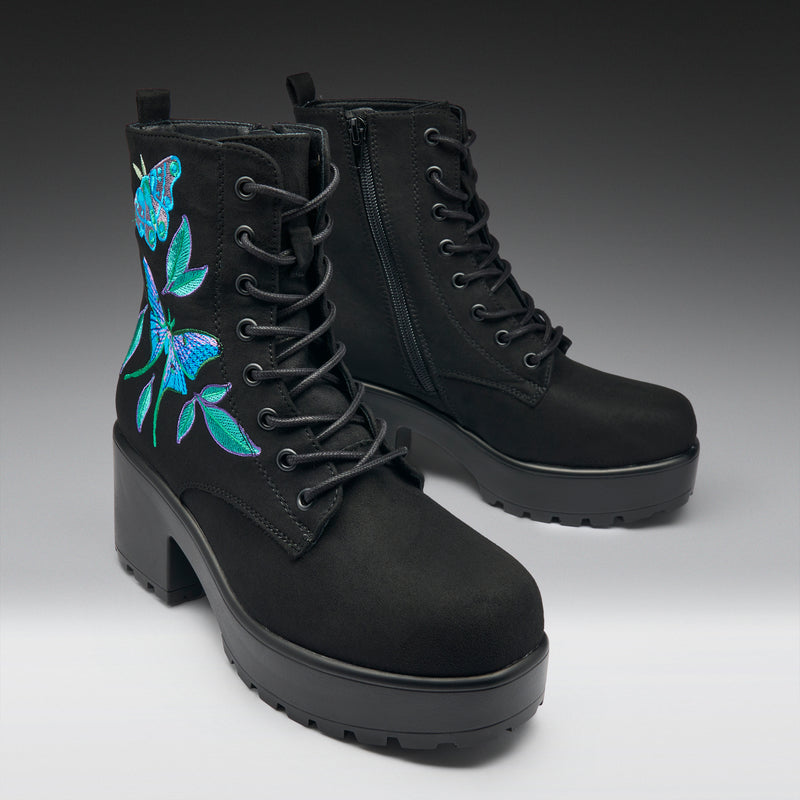 Black boots with floral embroidery on a gradient background
