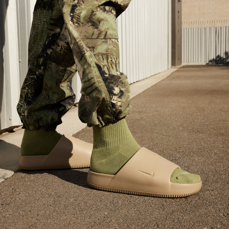 Khaki slide sandals worn with green socks and camo pants