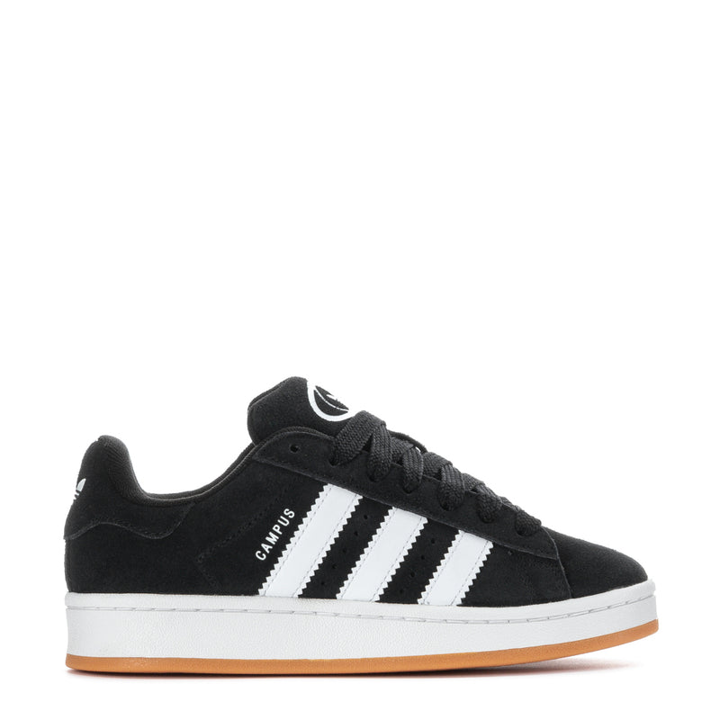 Youth black low-top sneakers with three white stripes and gum outsole