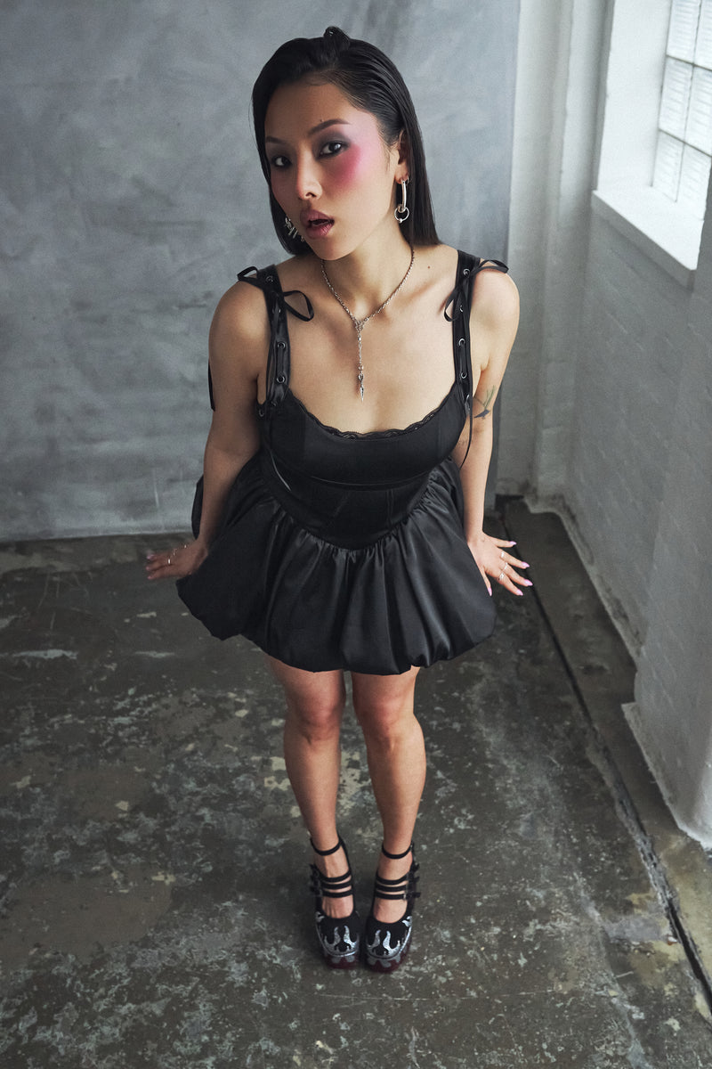 Woman wearing a black dress in an industrial setting