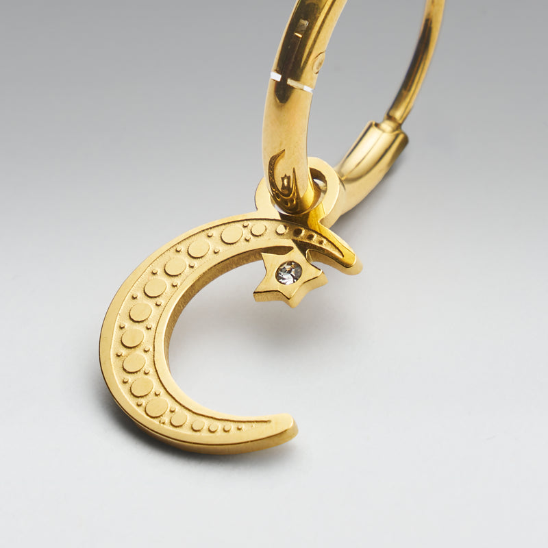 Gold crescent moon keychain with star detail on a gray background