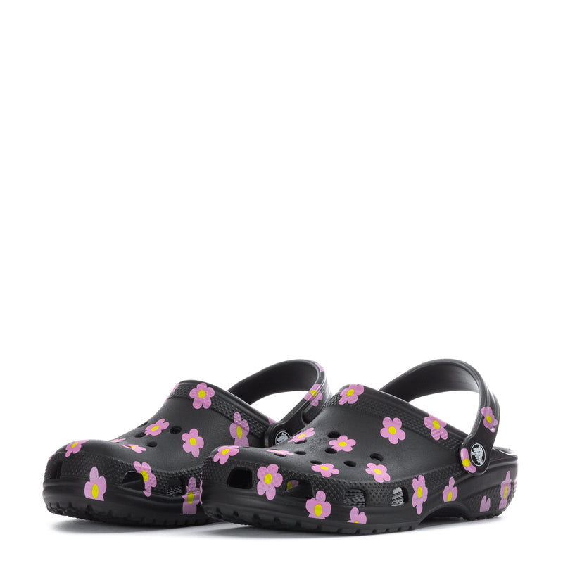 Kids' black clog with pink flower print, two shoes side-by-side with logo badge