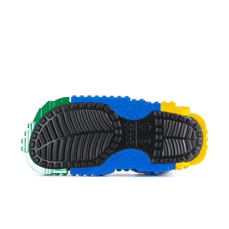 Men's clog outsole view with black tread and LEGO-brick colors in blue and green