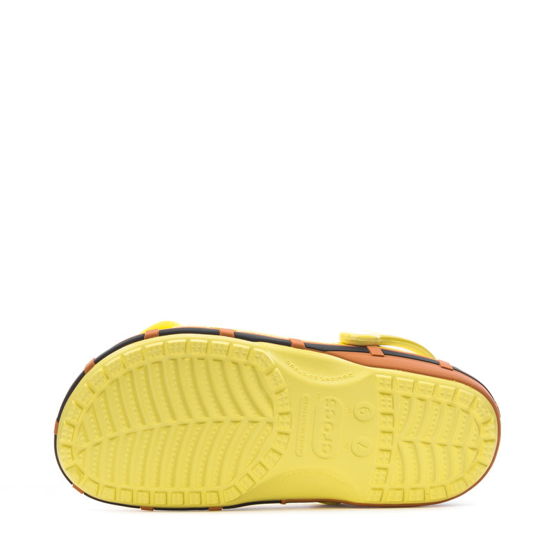 Men's yellow clog outsole view with textured tread and molded logo, black edge trim