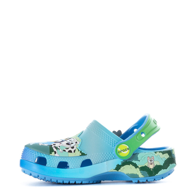 Toddler light-blue clog with animal graphic and green heel strap, angled side view.