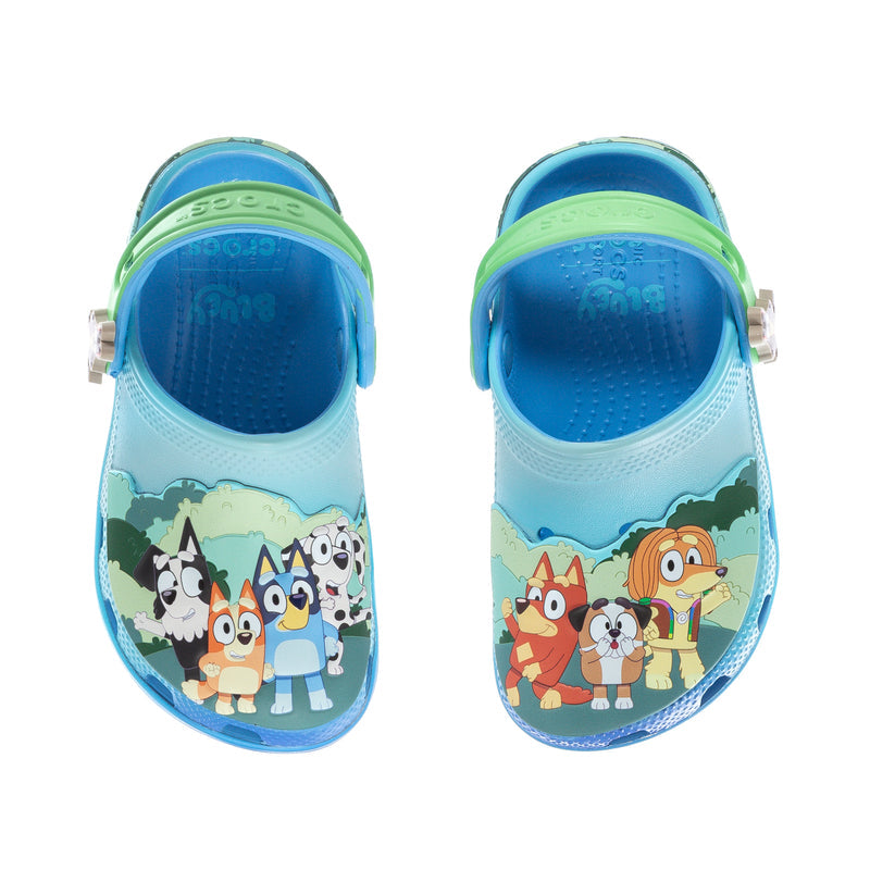 Toddler blue clog with animal graphic and neon green heel strap, top view.