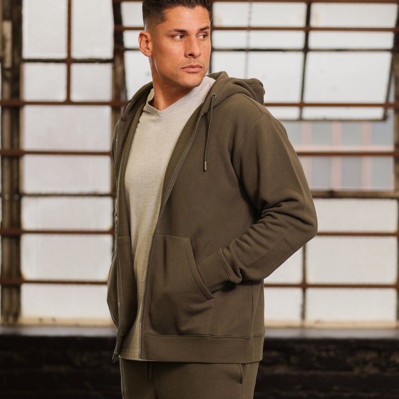 Men's olive fleece zip hoody on model, side view with front pouch pocket