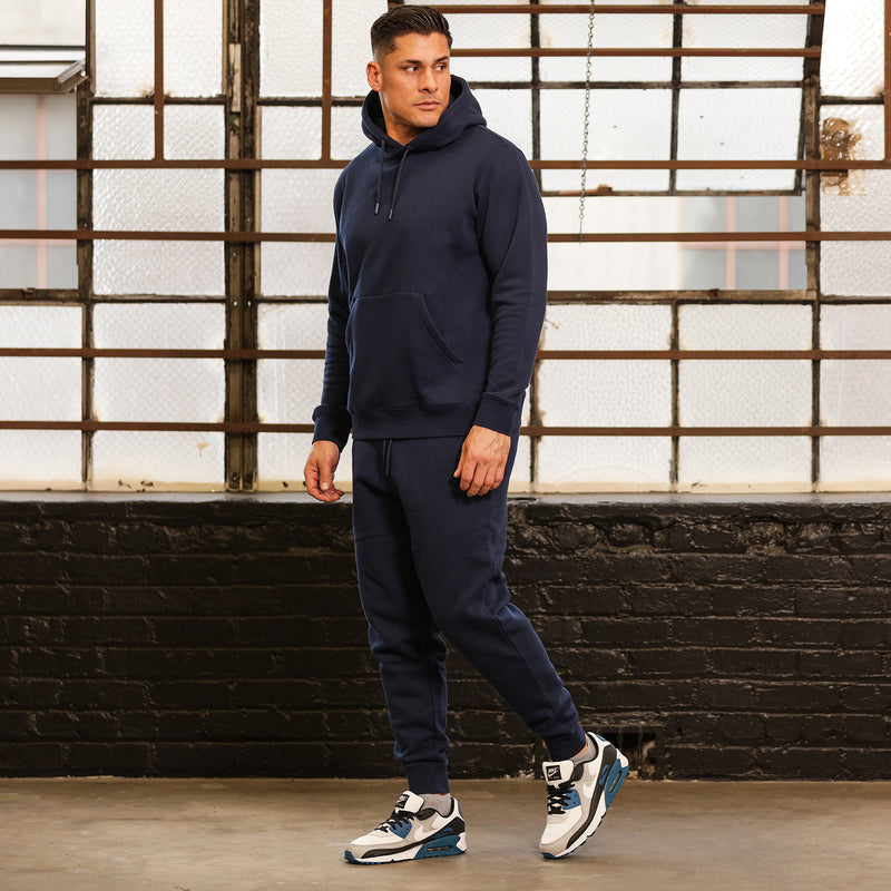 Men’s navy fleece pullover hoodie on model, side view with hood and pocket