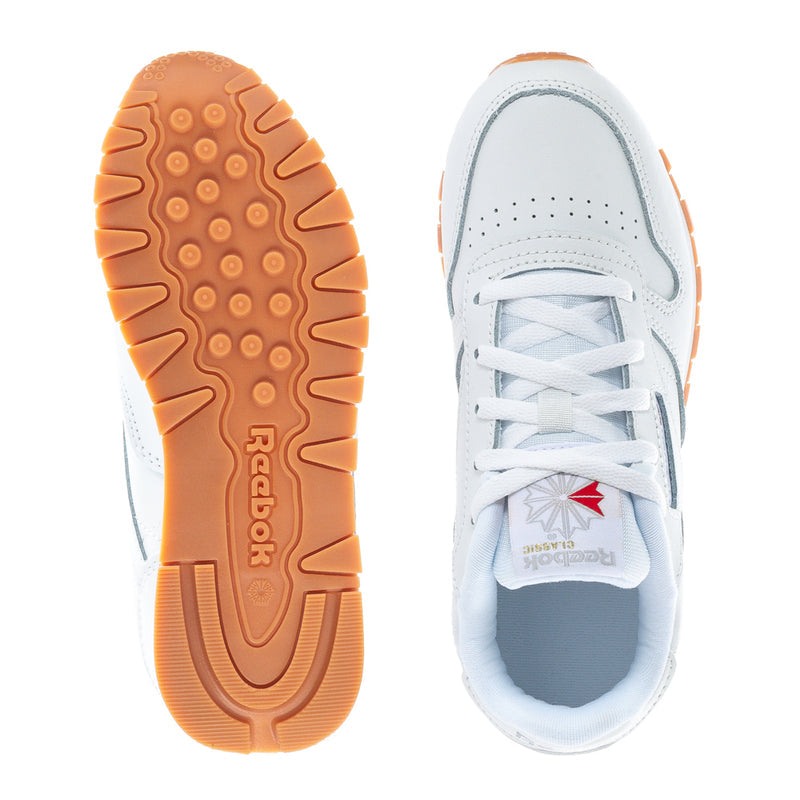Kids Reebok white sneaker showing gum outsole tread and blue-tinged lining