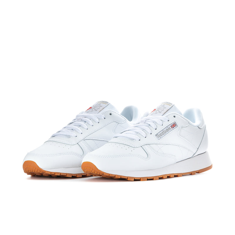Pair of men's white Reebok leather sneakers with gum outsole, side profile