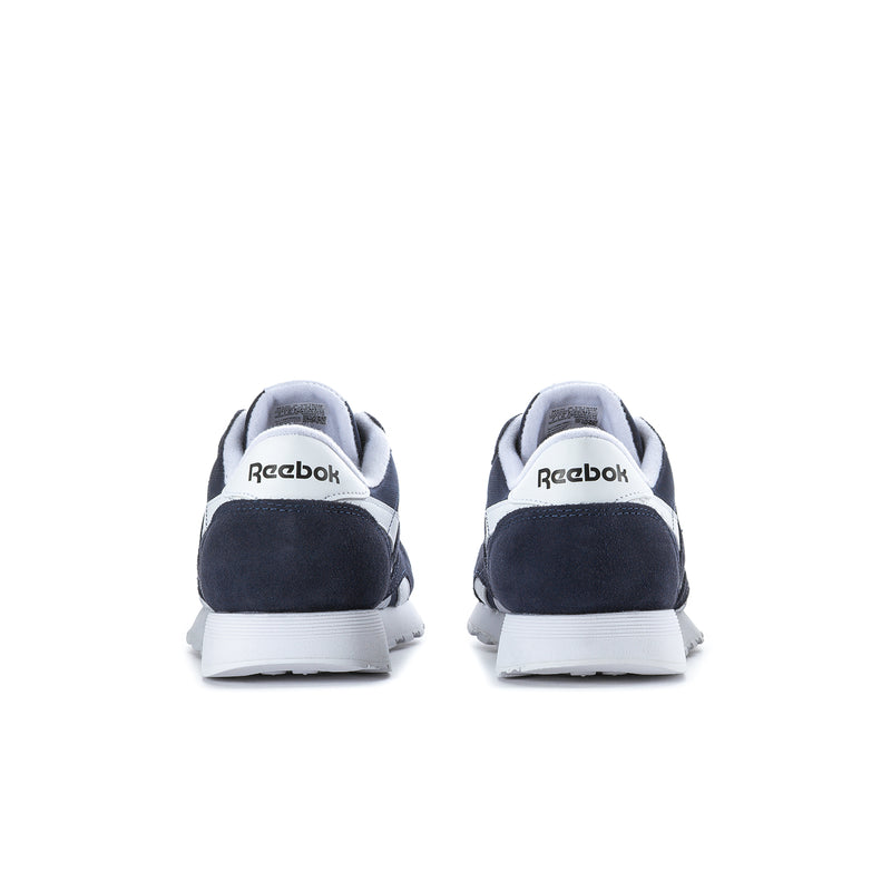 Men's navy low-top sneakers, rear heel view with white sole and Reebok branding.