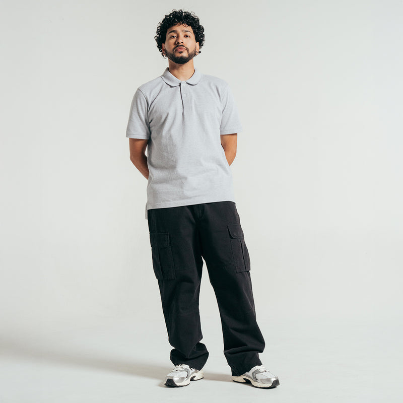 Men's heather grey pique polo shirt on model, standing with collar and buttons