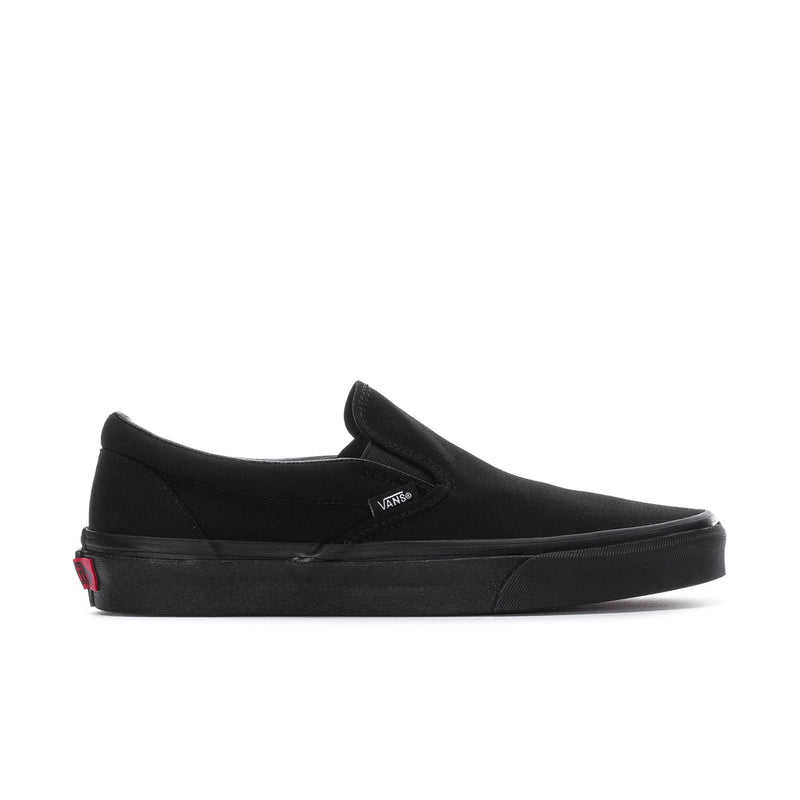 Black slip-on sneakers with Vans logo and red heel detail, low rubber outsole