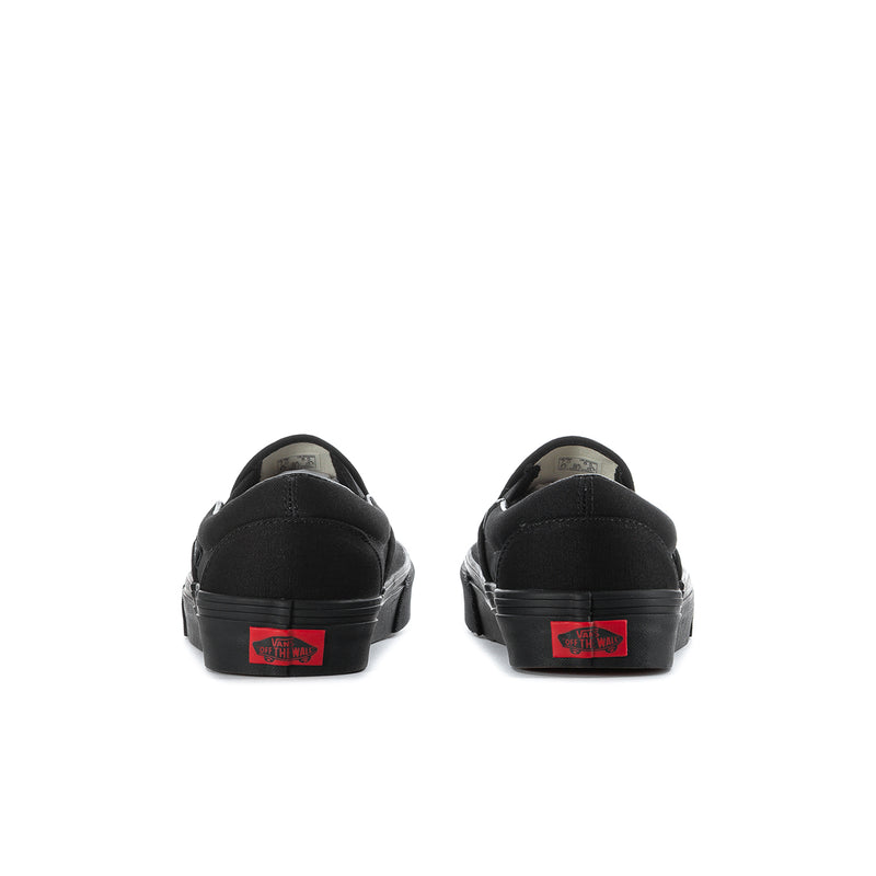 Black slip-on sneakers heel view with red Vans logo patch
