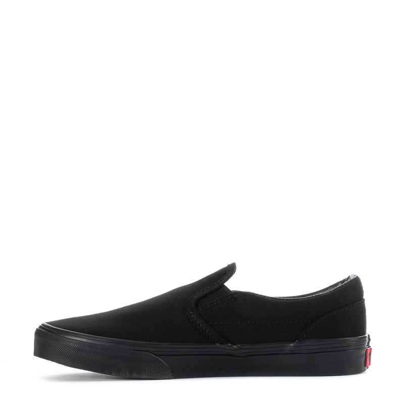 Vans youth black canvas slip-on sneakers, side view with red heel detail