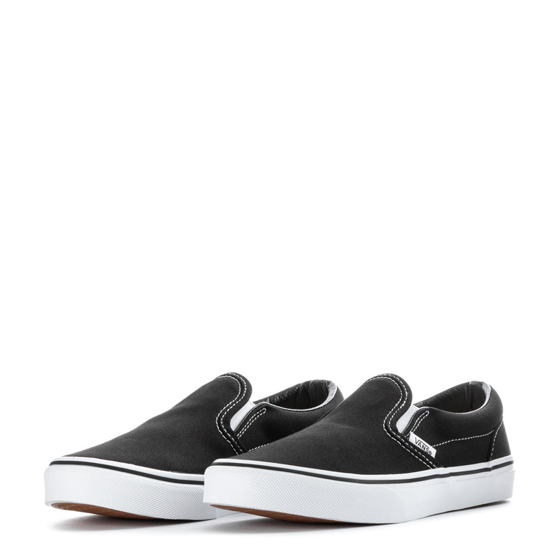 Pair of youth black slip-on sneakers with white soles and stitched side panels