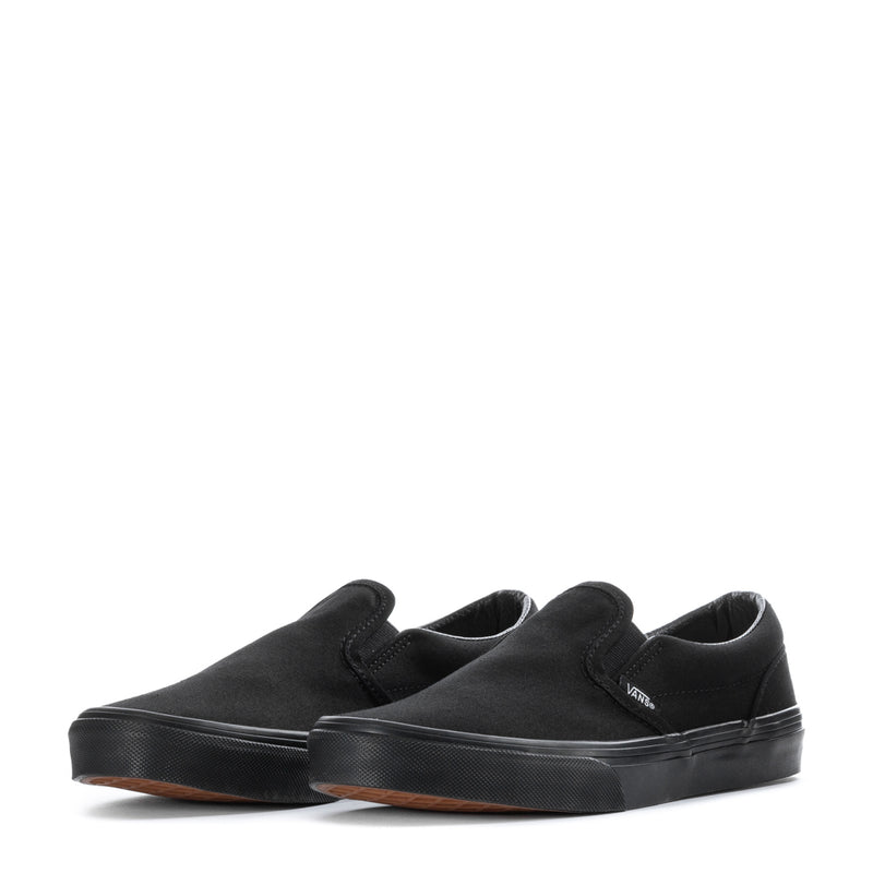 Vans youth black slip-on sneakers, pair view with gum-colored outsole edge