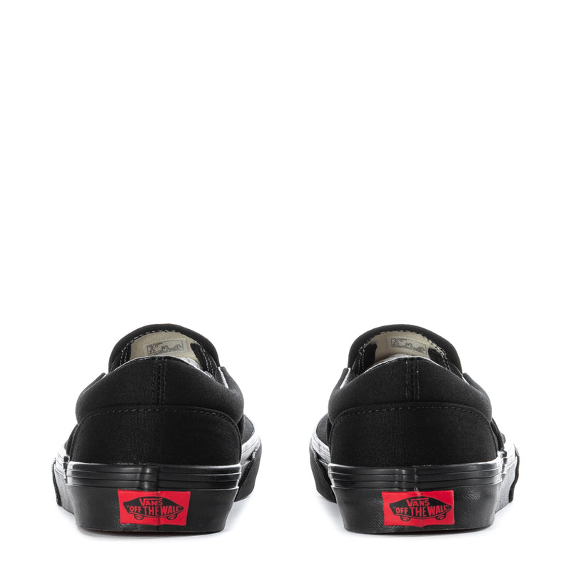 Vans youth black slip-on sneakers, back view with red logo patch on heel
