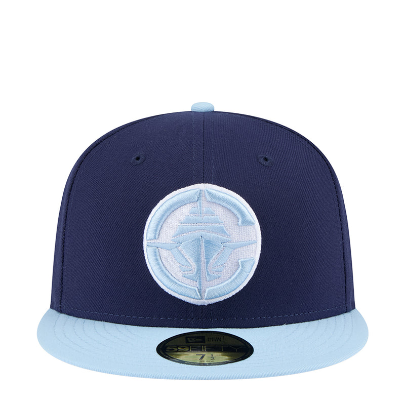 Two-tone baseball cap with navy crown and light blue brim, front circular logo patch