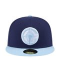 Two-tone baseball cap with navy crown and light blue brim, front circular logo patch