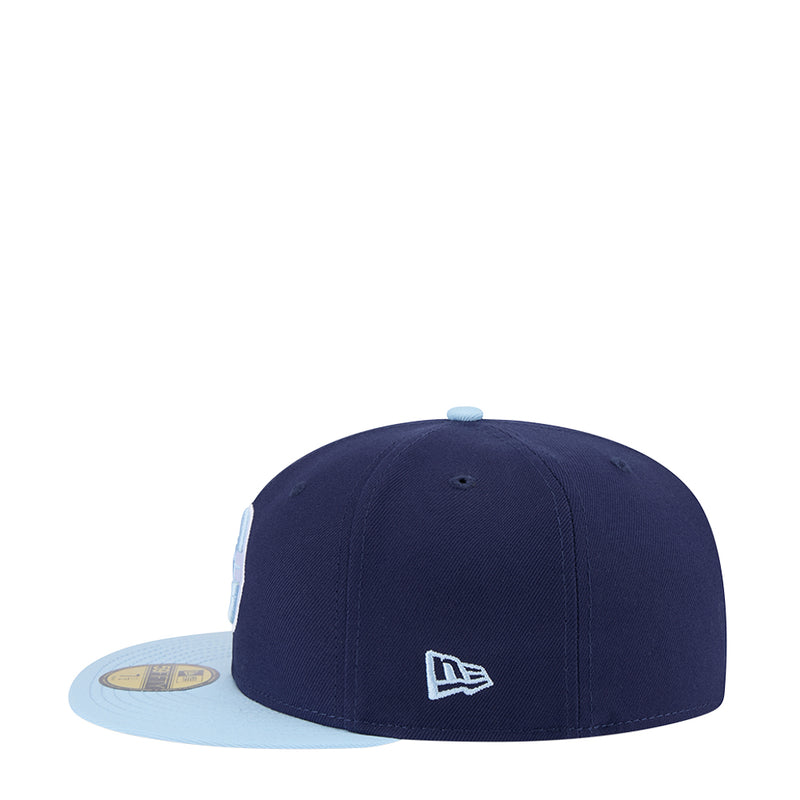 Two-tone baseball cap with navy crown and light blue brim, small square logo on front