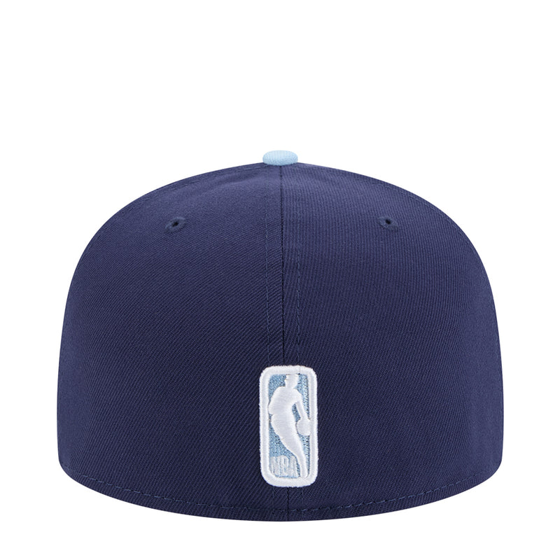 Two-tone baseball cap with navy crown and light blue brim, stitched vertical emblem patch