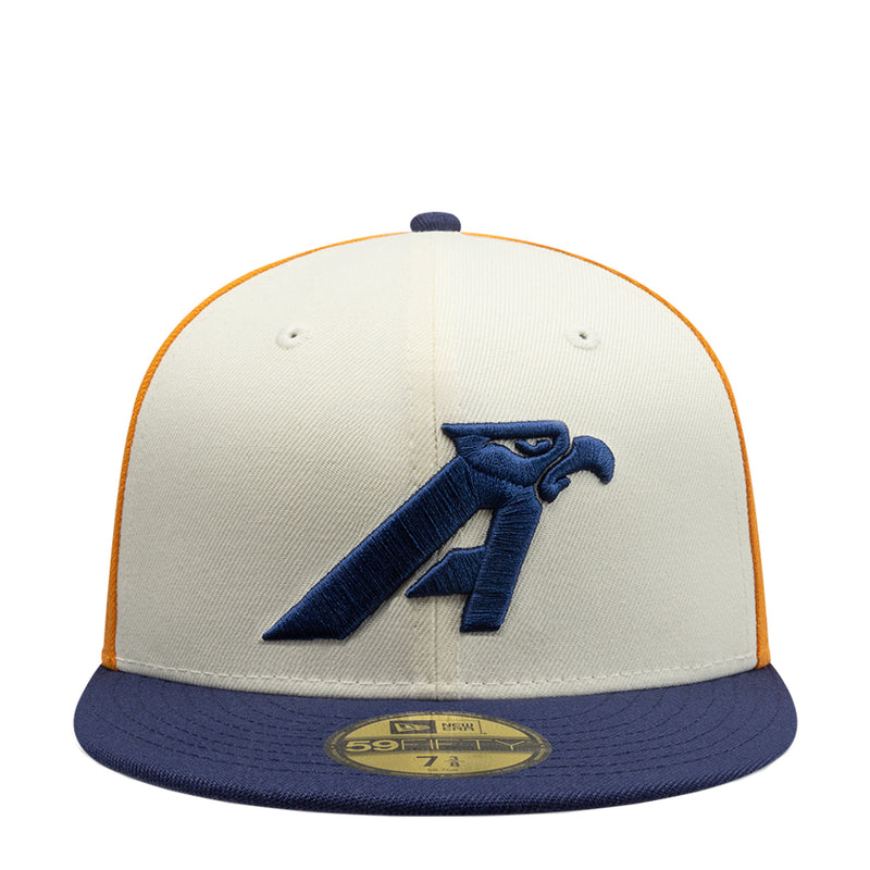 Tri-tone baseball cap with cream crown, navy brim, and embroidered blue letter logo
