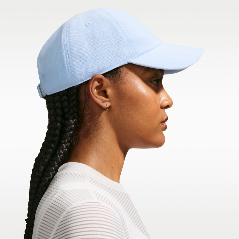 Light blue Nike cap with adjustable strap detail, side view and curved brim