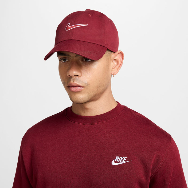 Maroon Nike baseball cap on model, white Swoosh logo on front