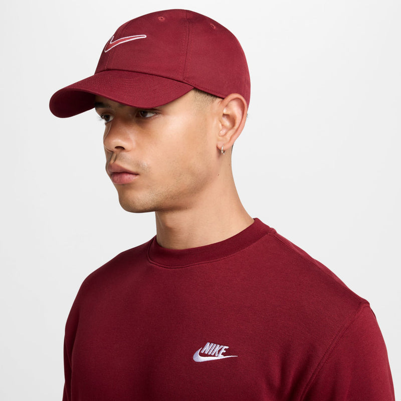 Maroon Nike baseball cap on side, white Swoosh logo on front panel