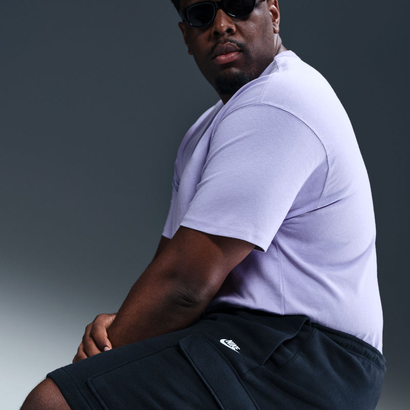 Men's black cargo shorts close-up: elastic waistband and side pocket with logo