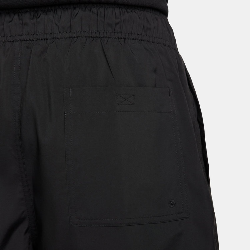 Close-up of black shorts front with elastic waistband, stitching, and logo
