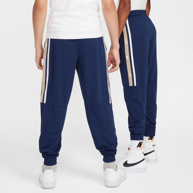 Youth navy joggers with contrasting side stripes and ribbed cuffs, rear view.