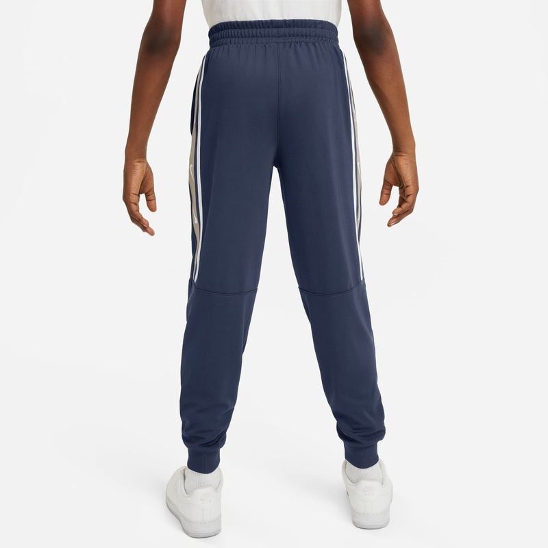 Youth navy jogger pants from back with elastic waist, tapered legs, and stripe accents.