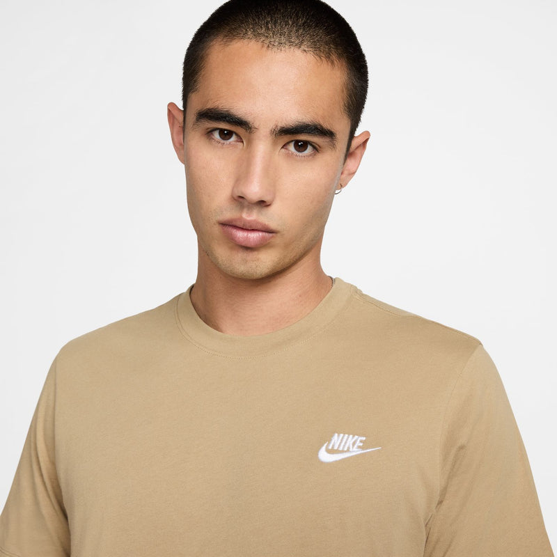 Men's beige club tee close-up showing white Nike logo on the chest