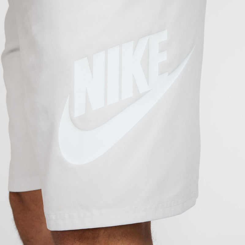 Men's white woven shorts with large Nike logo print on the leg