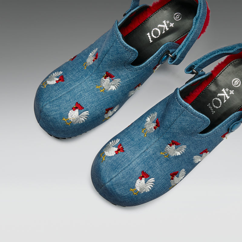 Blue shoes with chicken embroidery on a gray background