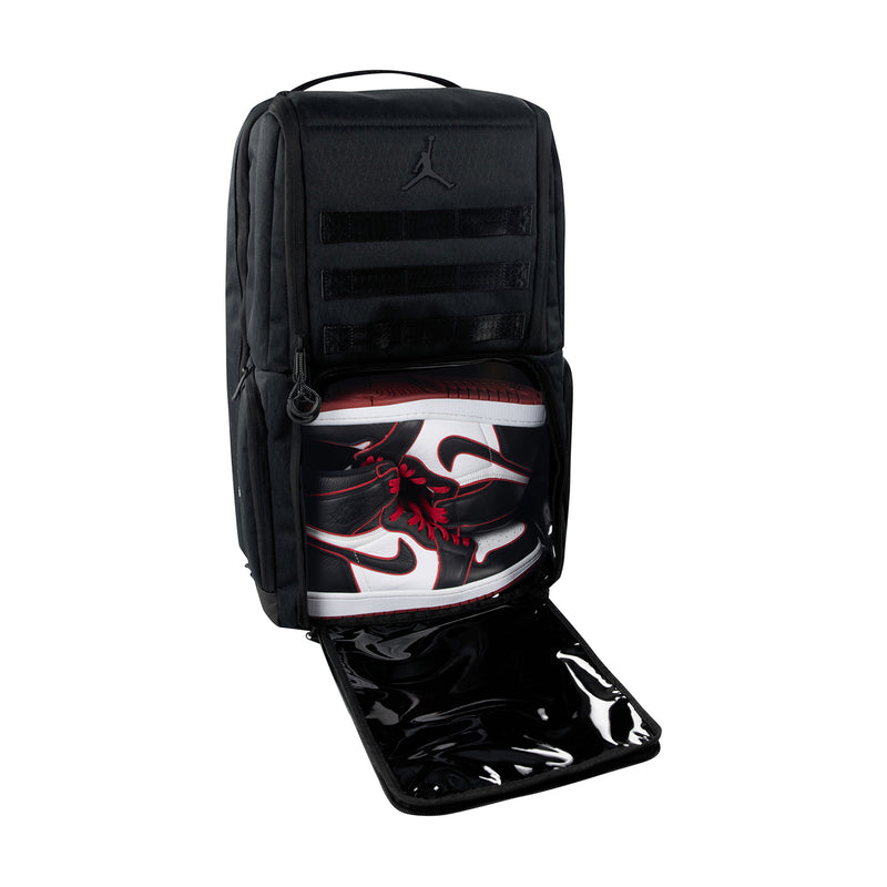 Black backpack with open front compartment and visible shoe-shaped insert