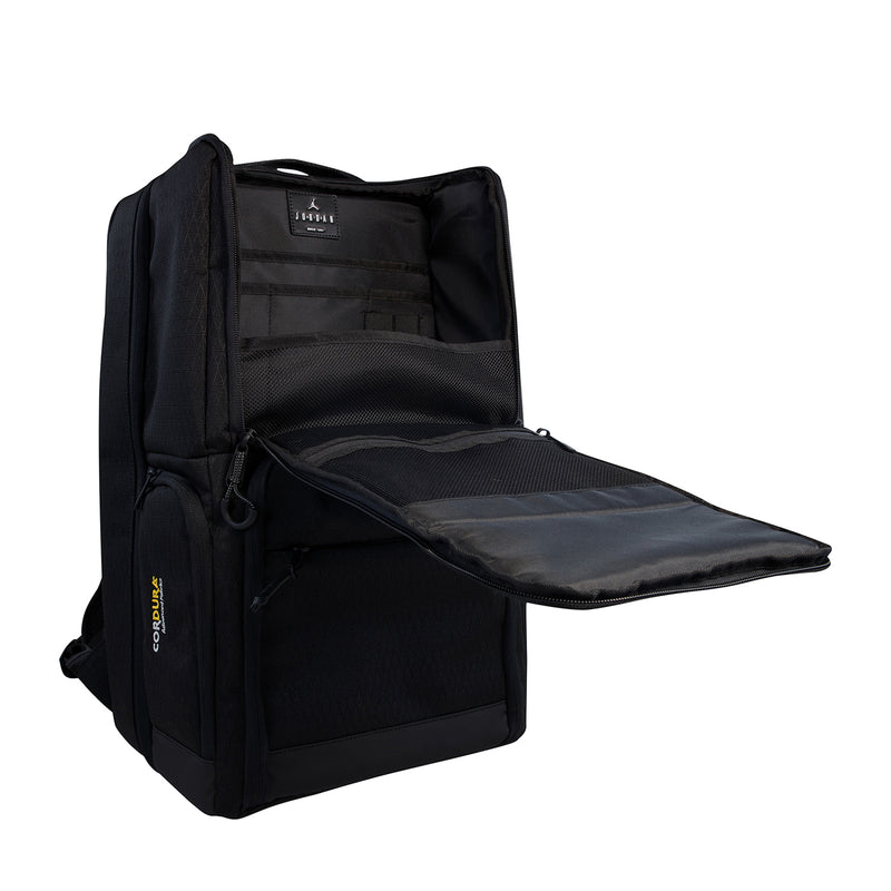 Black backpack open, showing interior padding and zippered side pocket