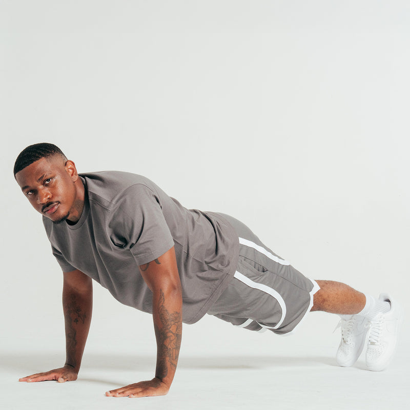Gray athletic shorts with white contrast tape hem, worn with white crew socks