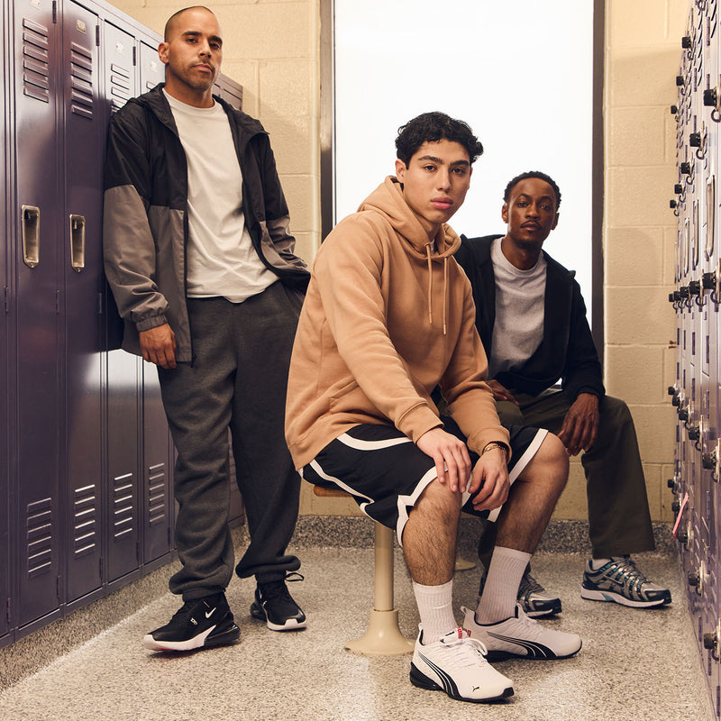 Men's contrast tape shorts worn with socks; dark shorts with white tape trim at hem