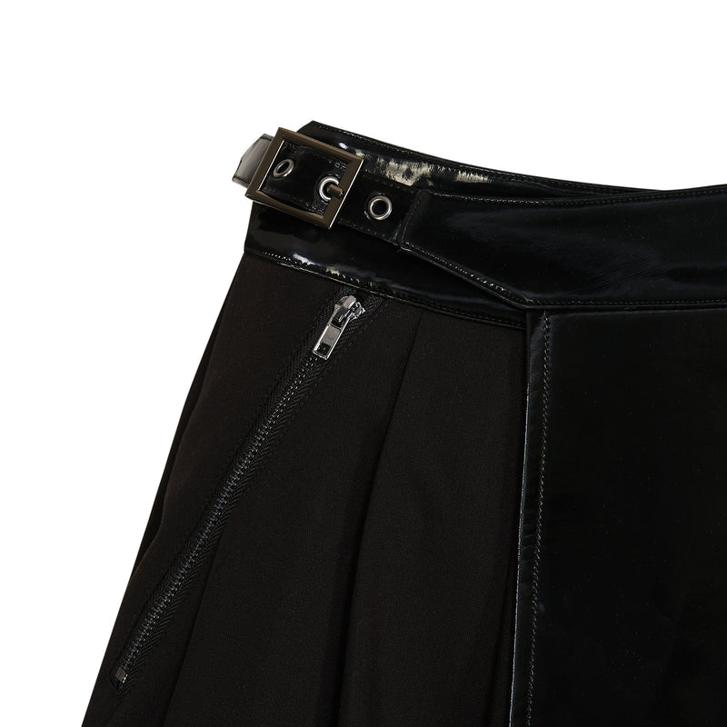 Close-up of a black leather jacket with a zipper and belt on a white background