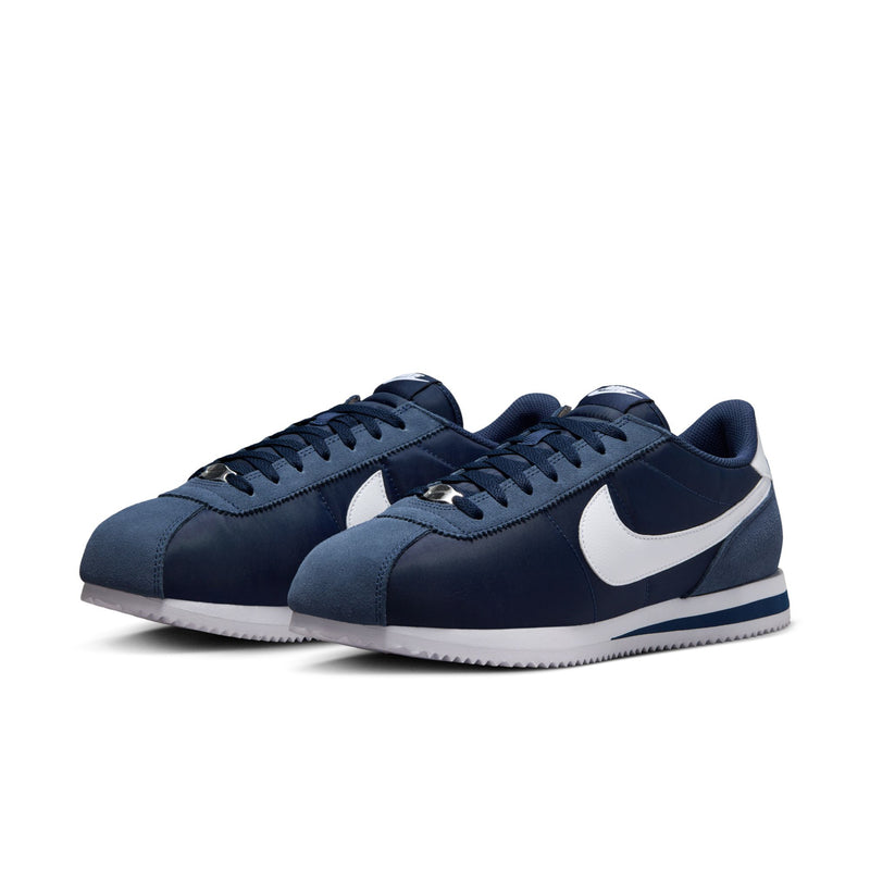 Men's navy Cortez sneakers, angled view; white swoosh and striped midsole