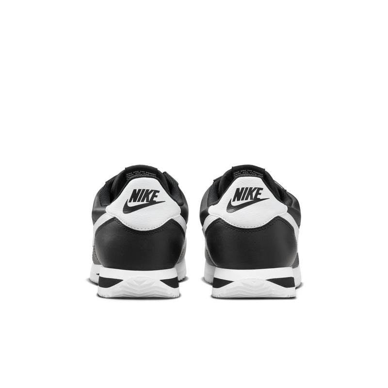 Men's black Nike Cortez sneakers, rear view with white heel accents